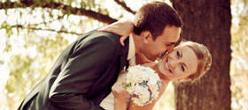 Young married couple smiling after the ceremony with bouquet in hand