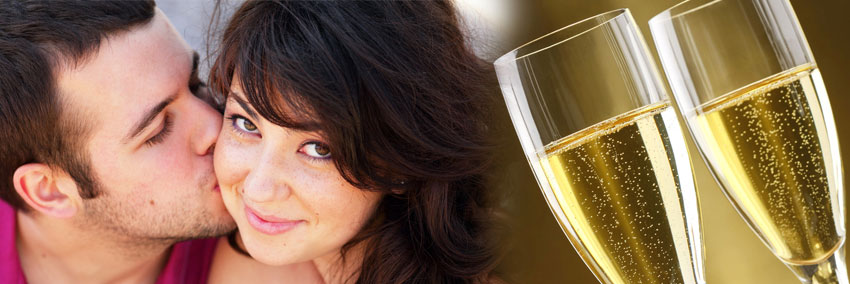 Man kisses his fiancee on the cheek, with champagne glasses